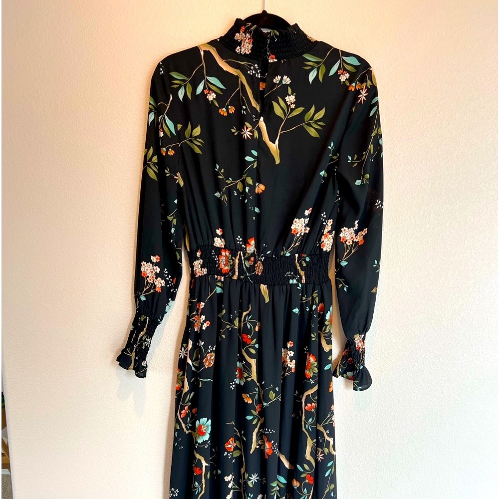 High-low dress silhouette to enhanced the flow. Smocked high neck ruffle wrist.